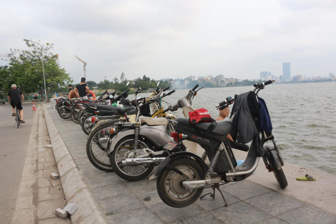 Trên bờ chật kín xe cộ, tư trang của người đến tắm.