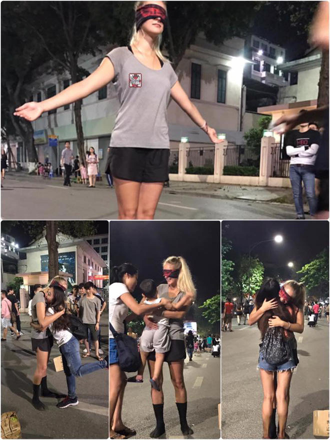 Cô gái trẻ đứng giữa phố, bịt mắt dang tay đón nhận những cái ôm.