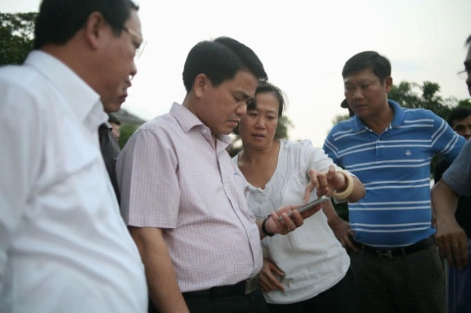 Chủ tịch Nguyễn Đức Chung thị sát và chỉ đạo việc khắc phục cá chết hàng loạt. (Ảnh Báo Giao Thông).