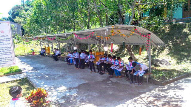 Các em học sinh đọc sách báo mỗi giờ ra chơi.