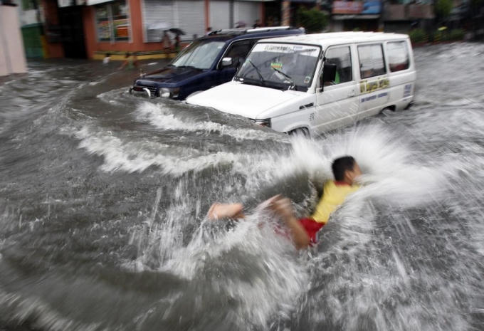 Một cậu bé bơi qua đoạn đường bị ngập khi bão Muifa đổ bộ vào Philippines năm 2011. (Ảnh: Reuters)