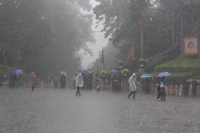 6h30, trời bắt đầu đổ cơn mưa, nhưng lực lượng chức năng cùng sinh viên tình nguyện vẫn đứng dưới cơn mưa tầm tã để đảm bảo an ninh trật tự. Hàng vạn người dân cũng đứng chịu mưa, kiên trì chờ đến giờ để được vào dâng hương sớm nhất.