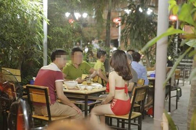 Nữ nhân viên tới các bàn ăn của khách phục vụ.