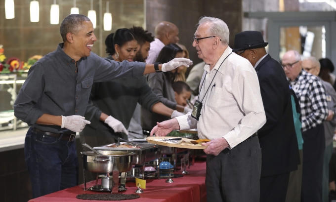 Tổng thống Obama luôn vui vẻ bắt tay và nở nụ cười thân thiện đối với các cựu binh. Ông phục vụ món gà tây và nước sốt. (Ảnh: AP)