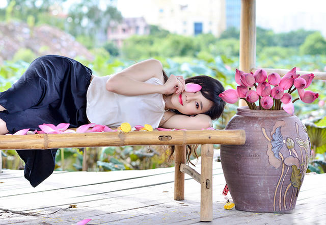 Phần đông những người tới chụp ảnh với sen là các cô gái trẻ. Các bạn thường chọn trang phục áo yếm tạo dáng bên hoa sen.