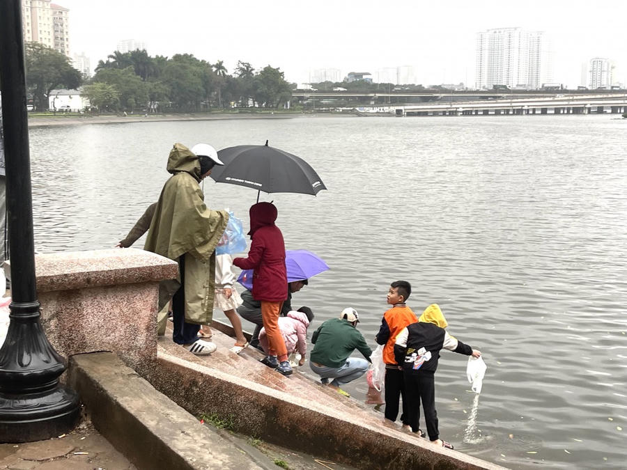 Những em nhỏ theo bố mẹ ra hồ thả cá chép