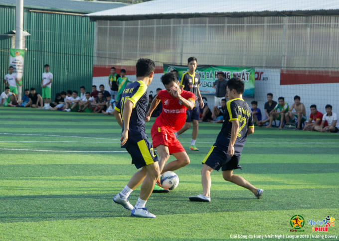 Cầu thủ FC Mần ( áo đỏ) giữa vòng vây của các cầu thủ  FC Tân Kỳ (áo đen).