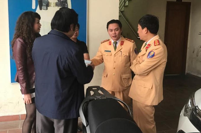 Đại diện đội CSGT số 2 bàn giao chiếc xe máy SH cho chị Hoa.
