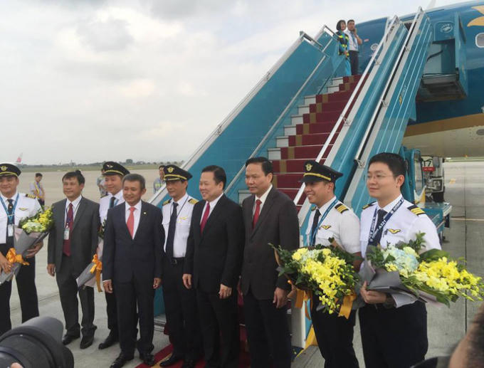 Ông Nguyễn Hoàng Anh (thứ 4 từ phải qua), Tổng giám đốc Vietnam Airlines Nguyễn Trí Thành cùng các vị khách mời tặng hoa đội bay tại lễ đón