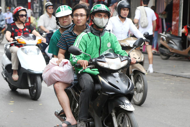 Tài xế GrabBike chở 3 ở phố Hàng Ngang, Hàng Đào, nhiều hành khách còn không có mũ bảo hiểm để đội.