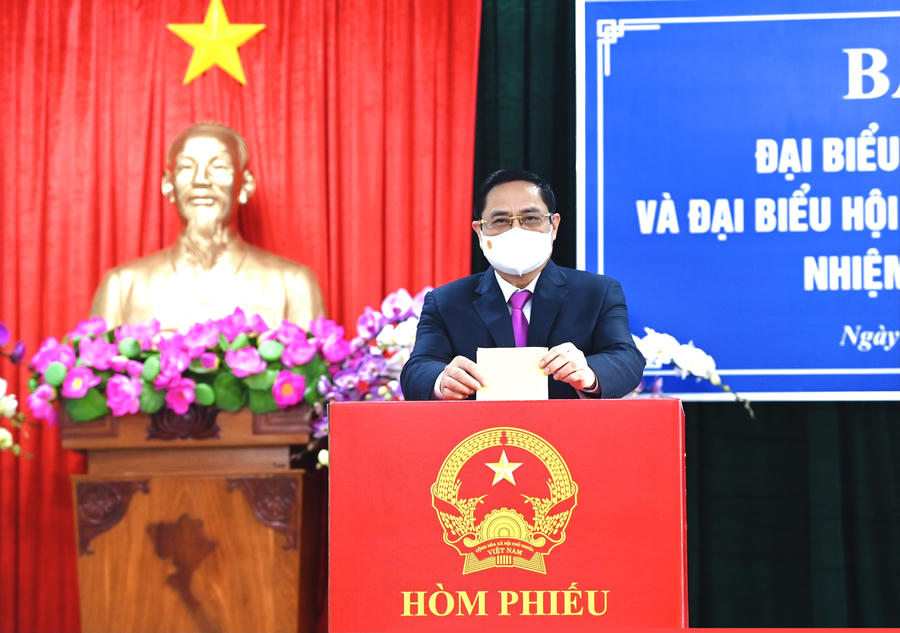 Thủ tướng Phạm Minh Chính là người bỏ lá phiếu đầu tiên vào hòm phiếu tại khu vực bỏ phiếu số 18.  Ảnh: VGP/Nhật Bắc
