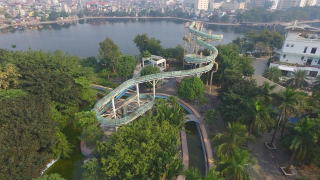 Một góc khu công viên nước nhìn từ trên cao. Dễ nhận thấy ống trượt nước khổng lồ bị bỏ không đã lâu, rêu xanh phủ khắp.