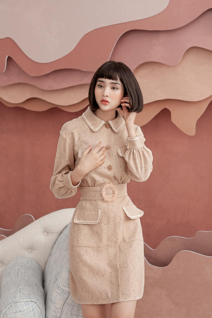 Hiền Hồ gợi ý một thiết kế kín đáo với gam màu be nhã nhặn, phù hợp các chị em công sở. Điểm nhấn nằm ở những chiếc khuy được đính thủ công bằng đá, ngọc trai và phần đai lưng to bản.