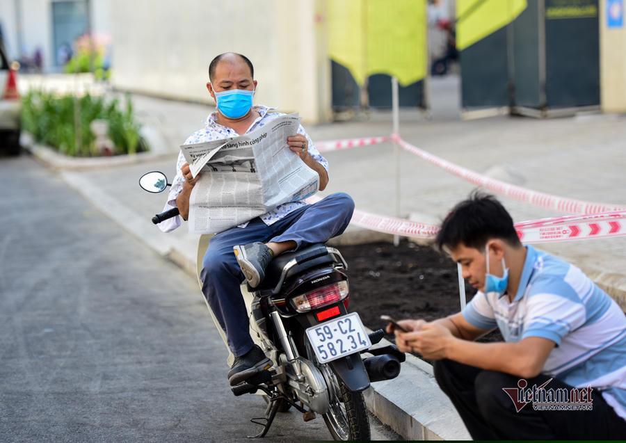 Người dân đọc báo, xem điện thoại trốn nóng