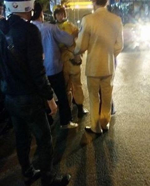 Một chiến sỹ CSGT đang được đồng nghiệp cùng người dân đưa đi cấp cứu.