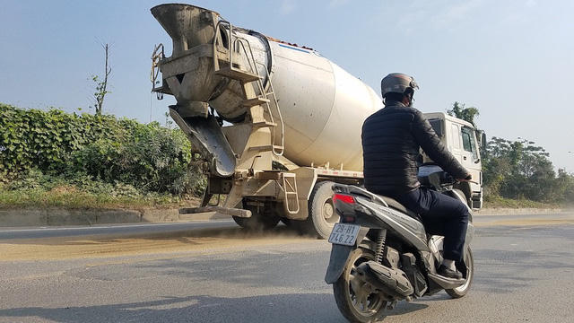 Nhiều ụ bụi, cát đọng lại trên mặt đường gom Đại lộ Thăng Long.