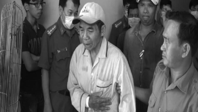 Ông Chuyền (áo kẻ sọc) bị cơ quan công an tạm giữ.