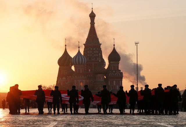 Những người tham gia diễu hành căng lá cờ Xô Viết tập trung trước Nhà thờ St. Basil.