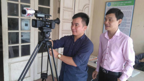 Phóng viên Đinh Hữu Dư (trái) trong lúc tác nghiệp.
