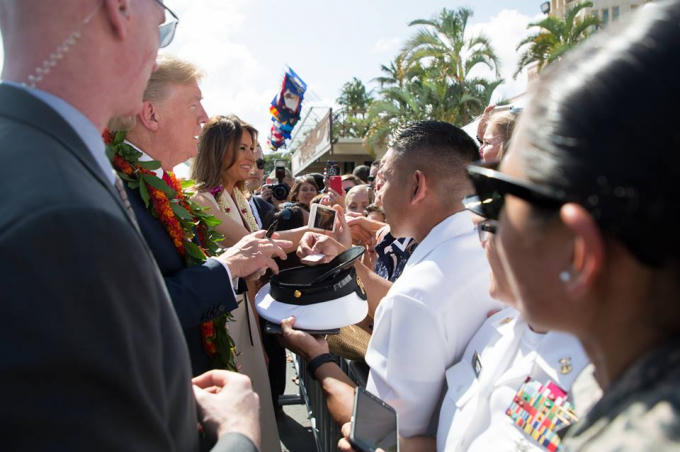 Tổng thống Trump cùng phu nhân đã ký ảnh, giao lưu với trẻ em đứng cùng với dân thường và quân nhân đang đón chào mình.