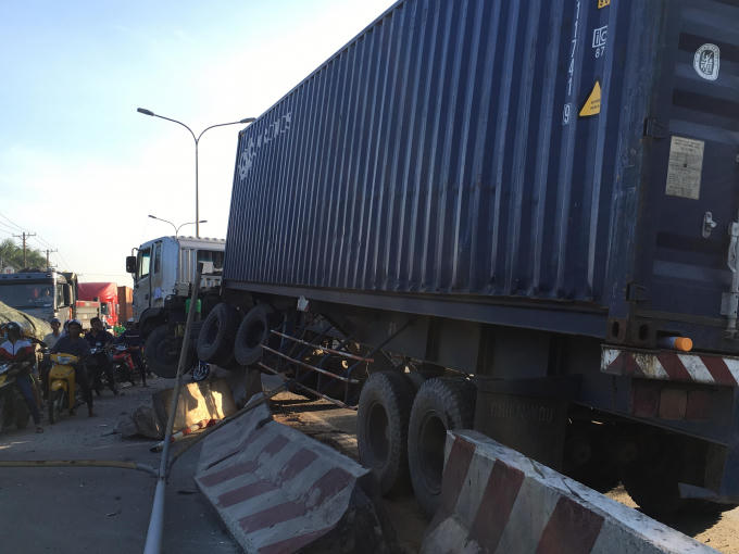 Đầu container nằm vắt vẻo trên dải phân cách.