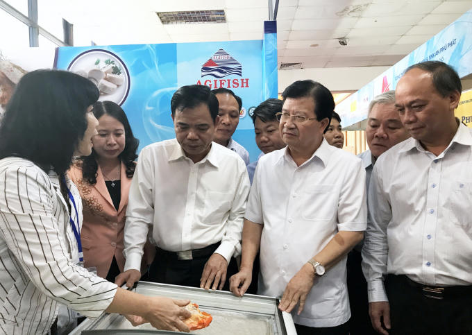 Phó Thủ tướng Trịnh Đình Dũng trao đổi với đại diện các DN thủy sản có mặt tại Hội chợ. Ảnh: VGP/Xuân Tuyến