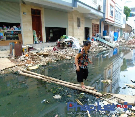 Người dân phải bắc cầu để có thể đi qua mặt đường.