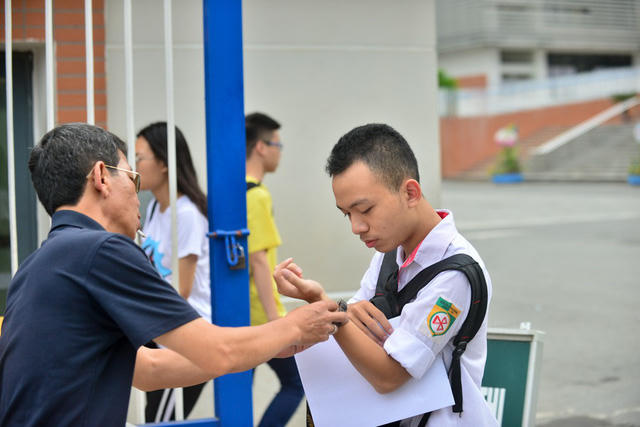 Phụ huynh chăm chút cho con trước khi vào phòng thi môn Ngữ Văn, ảnh chụp tại điểm thi Trường THPT Chuyên Hà Nội - Amsterdam sáng 25/6/2018. (Ảnh: Toàn Vũ)