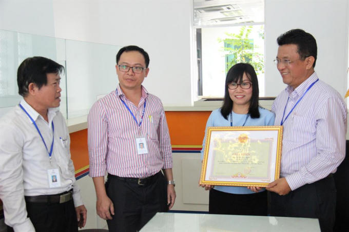 Chị Trần Thị Anh (áo xanh) được lãnh đạo công ty điện lực Đà Nẵng khen thưởng vào ngày 7/3 vừa qua.