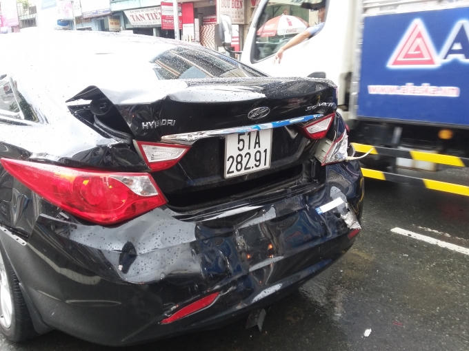 Các phương tiện hử hỏng sau va chạm. Các phương tiện xếp hàng dưới mưa.