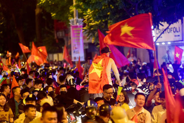 Dòng người đổ về dọc tuyến phố Hàng bài, khoác và cầm cờ tổ quốc hô vang chiến thắng.