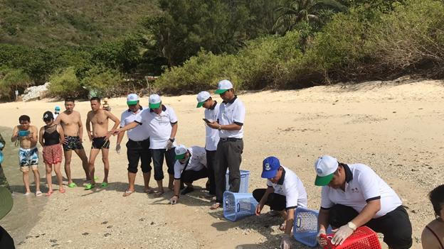 Các đại biểu cùng thả rùa con về biển trước sự chứng kiến của người dân và du khách trên hòn Bảy Cạnh. (Ảnh: Báo BRVT)
