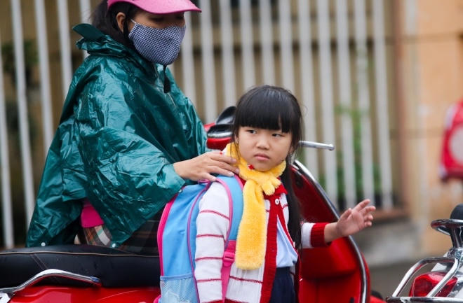 Một cô bé được mẹ quấn khăn len gọn gàng trước giờ vào lớp học trên đường Cộng Hòa, quận Tân Bình.