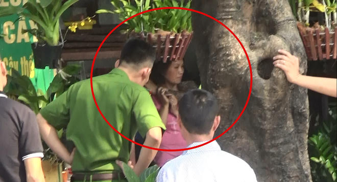 Người phụ nữ bị đối tượng dùng súng giả và dao khống chế (trong vòng tròn đỏ).