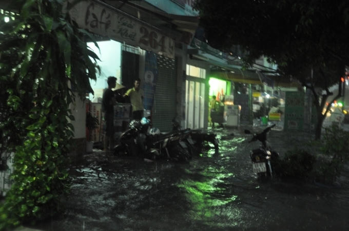 Nước ngập lên vỉa hè và tràn vào nhà dân.