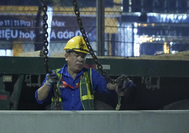 Các công nhân tập trung tháo dỡ hàng rào bê-tông trước cổng Liên đoàn bóng đá Việt Nam.