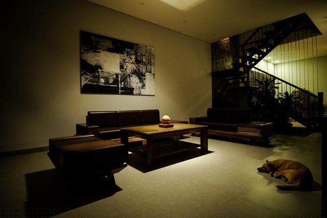 Không gian phòng khách sáng thoáng, rộng rãi. Anh Luân sử dụng bộ sofa gỗ kết hợp đệm da để mang lại cảm giác ấm áp, nhấn nhá thêm bởi bức tranh treo tường trắng đen hiện đại.