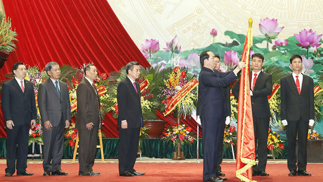 Chủ tịch nước Trần Đại Quang gắn Huân chương Lao động hạng nhất lên lá cờ truyền thống của Đảng bộ khối các cơ quan T.Ư. (Ảnh: TTXVN)