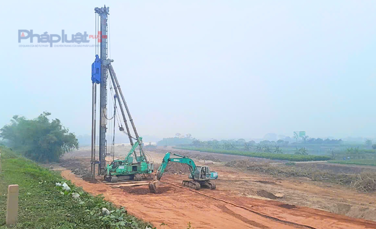 Công nhân, máy múc đang san gạt tạo hình mặt bằng.