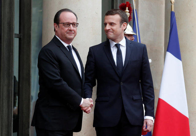 Ông Hollande (trái) bắt tay ông Marcon - chủ nhân kế tiếp của điện Elysee. (Ảnh: Reuters)