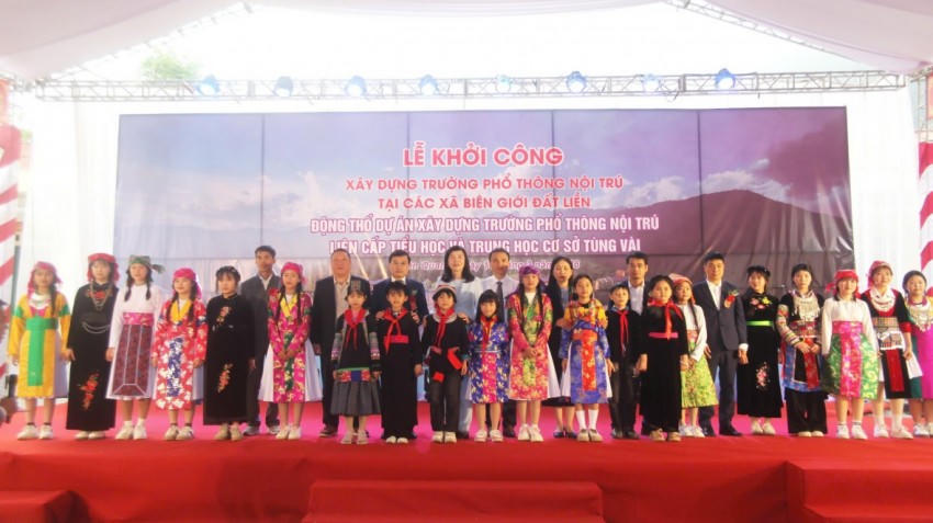 Các đại biểu chụp ảnh cùng học sinh tại điểm cầu khởi công xây dựng trường nội trú tại xã Tùng Vài. (Ảnh: Hoàng Chính).