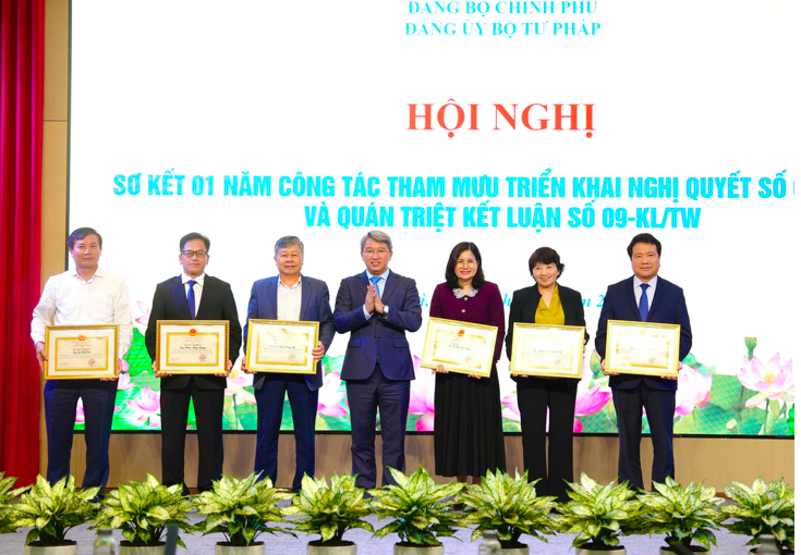Bộ trưởng Nguyễn Hải Ninh tặng Bằng khen của Thủ tướng Chính phủ cho các tập thể, cá nhân đã có thành tích xuất sắc trong công tác tham mưu xây dựng và triển khai tổ chức thực hiện Nghị quyết số 66-NQ/TW. Ảnh: VGP/KL