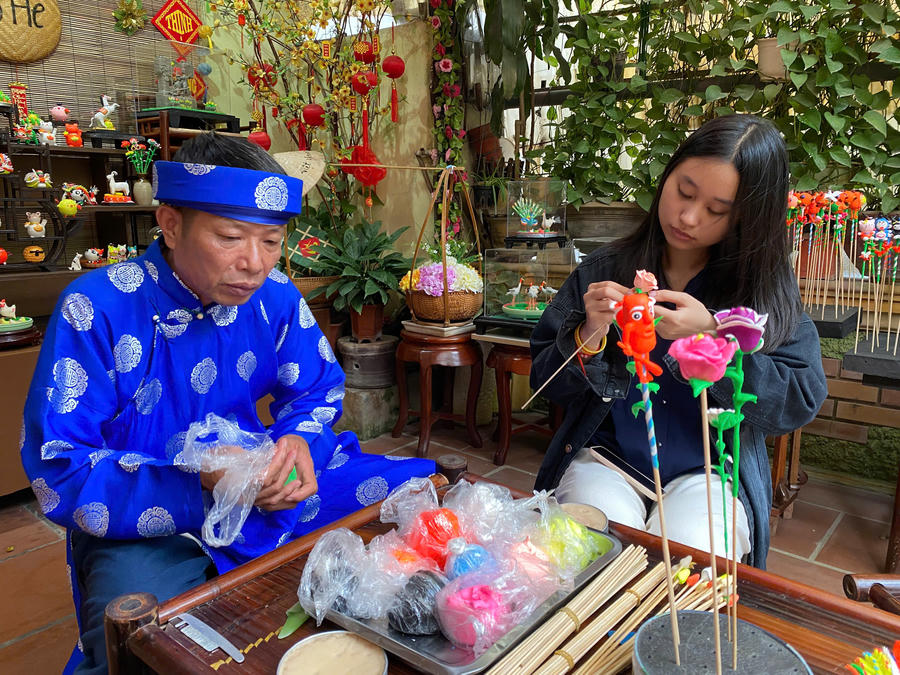 Nghệ nhân Đặng Đình Hơn hướng dẫn du khách nặn tò he.