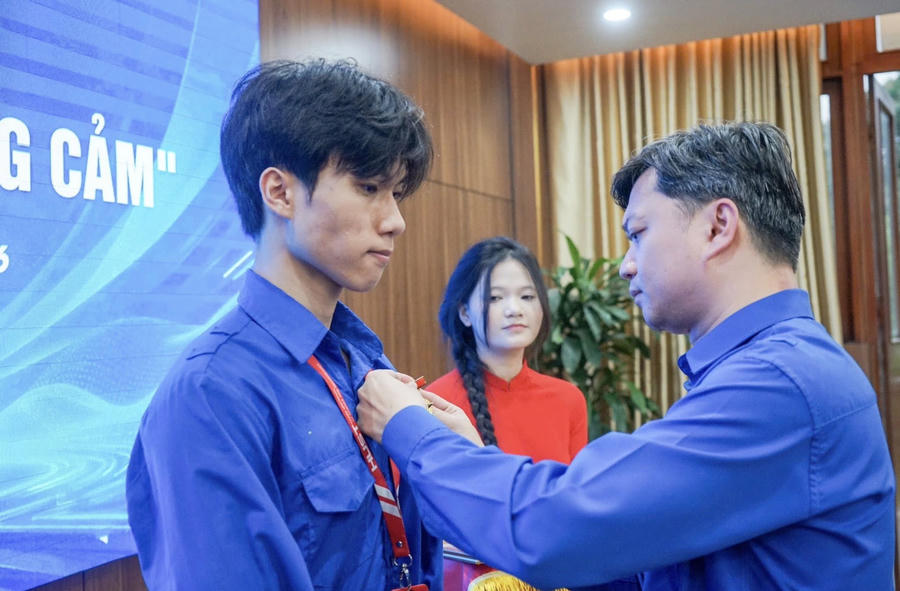 Anh Nguyễn Minh Triết trao tặng Huy hiệu "Tuổi trẻ dũng cảm" Bằng khen của BCH Trung ương Đoàn cho sinh viên Nguyễn Lê Tú.