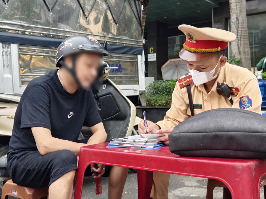 Cảnh sát giao thông xử lý trường hợp phụ huynh chở con không đội mũ bảo hiểm.