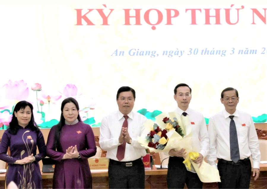 Ủy viên Trung ương Đảng, Bí thư Tỉnh ủy An Giang Nguyễn Tiến Hải (đứng giữa) và các đại biểu chúc mừng ông Nguyễn Thanh Nhàn (thứ hai từ phải sang) tiếp tục giữ chức vụ Chủ tịch HĐND tỉnh An Giang. 