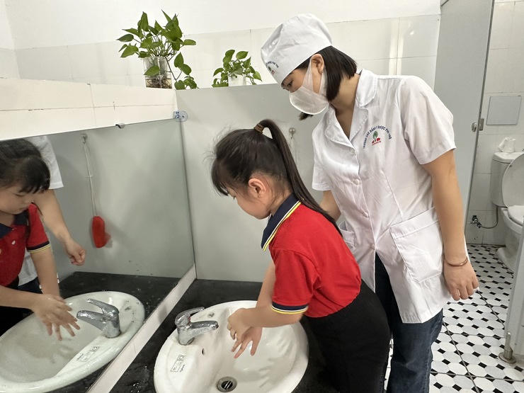 Cán bộ y tế hướng dẫn trẻ rửa tay đúng cách. Ảnh: SYTHN Cán bộ y tế hướng dẫn trẻ rửa tay đúng cách. Ảnh: SYTHN
