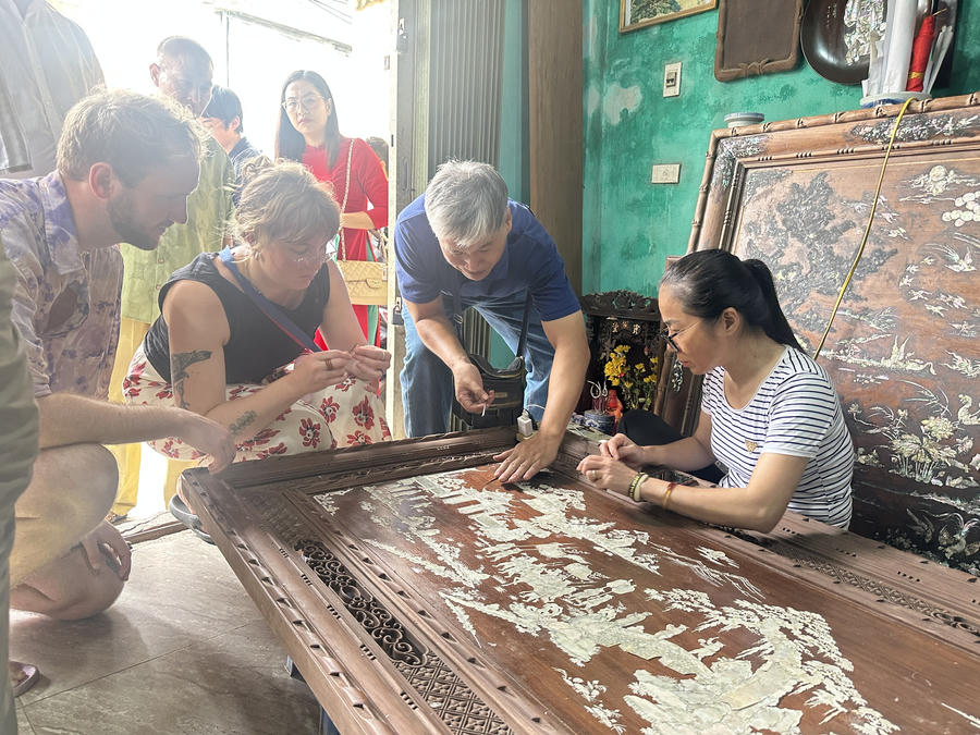 Tham quan làng nghề, du khách được các nghệ nhân hướng dẫn làm thử các sản phẩm khảm trai thủ công.