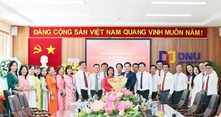Lãnh đạo Sở Nội vụ cùng tập thể sư phạm Trường Đại học Đồng Nai tặng hoa chúc mừng TS Đặng Anh Tuấn (Ảnh: Công Nghĩa).