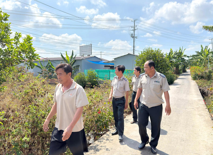 Ông Nguyễn Công Tân (bên trái) khảo sát thực địa diện tích đất của người dân để phục vụ việc thỏa thuận tự nguyện Thi hành án.